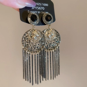 Detail of vintage French coin earrings with black stone and long gold chain tassels