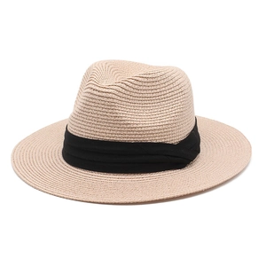 Detailed view of the fine woven spiral texture and black ribbon on a beige Panama hat