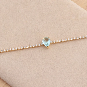 Elegante vergulde halsketting met lichtblauwe zirkoon druppel en kleine ronde kristallen