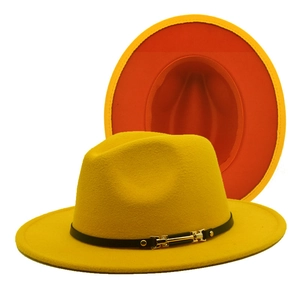 Detail of yellow fedora hat with orange brim lining, leather band and gold buckle