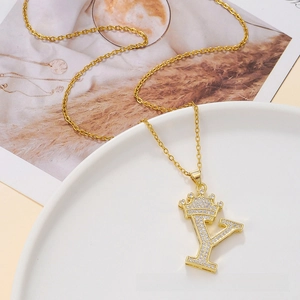Macro view of gold letter Y pendant with crown detail and pavé cubic zirconia