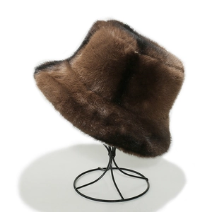 Winter plush faux fur bucket hat in brown tones displayed on a black metal stand