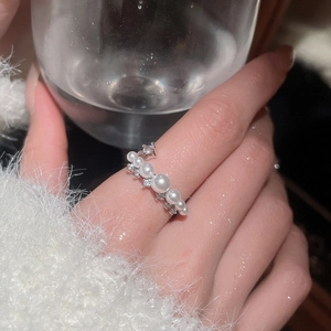 Detail shot of elegant silver pearl ring with sparkling cubic zirconia on a hand