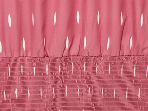 Détail de la robe rose avec découpes laser et texture de tissu élastique smocké
