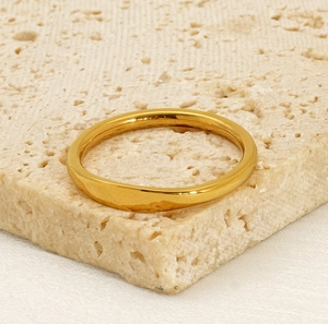 Polished 18K gold-plated stainless steel ring displayed on beige travertine stone