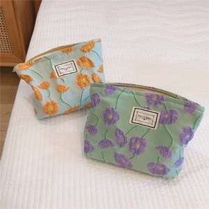 Detailed close-up of floral embroidery on cotton cosmetic bags with zipper closure