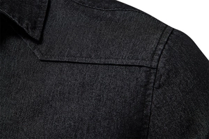 Detailed close-up of double-stitched shoulder seams on premium black denim shirt