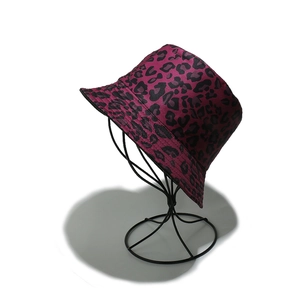 Detail of fuchsia leopard print bucket hat with black spots on a metal display stand