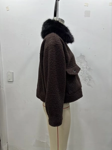 Détail d'une veste marron foncé texturée avec un large col en fausse fourrure noire
