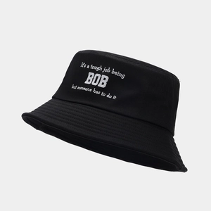 Dettaglio di cappello alla pescatora nero con cuciture parallele e slogan bianco stampato
