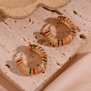 Detail of 18K gold plated hoop earrings with colorful enamel stripes on stone background