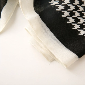 Macro shot of black and white houndstooth pattern fabric with detailed weave and texture