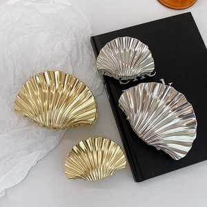 Glossy seashell-shaped metal hair claws in gold and silver finishes for women