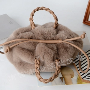 Detailed macro view of faux rabbit fur tote bag featuring a woven leather handle