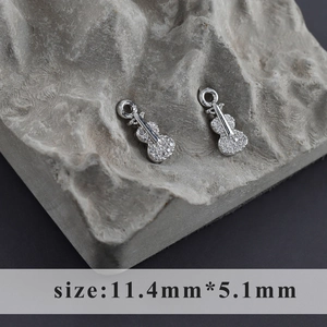 Macro detail of rhodium plated violin pendant with white zircons, size 11.4mm by 5.1mm