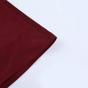 Vue macro de la texture du satin rouge foncé et des détails de couture sur la robe