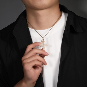 Close-up of golden crown cross pendant with cubic zirconia on a Cuban chain