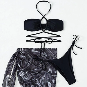 Detailed flat lay of three-piece bikini set with marble print sarong and black strappy top