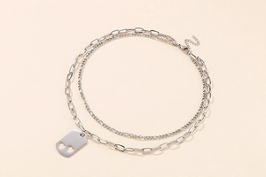 Detail view of double-layered silver necklace with heart cutout rectangular pendant charm