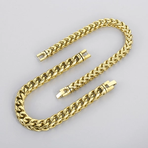 Flat lay of gold-tone Cuban link necklace and bracelet set with metallic luster finish