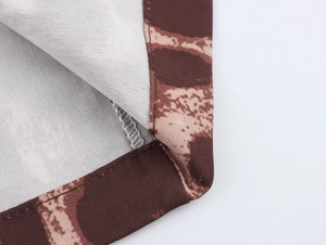 Close-up of leopard print fabric texture and precise stitching on the hem of the garment