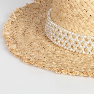Elegant raffia straw hat with layered pearl trim and fringed edges for beach holidays