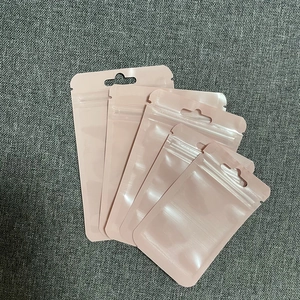 Close-up of four pink resealable plastic pouches with zipper closure and hanging hole