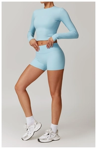 Détail d'un ensemble de yoga bleu clair avec haut court à manches longues et short taille haute