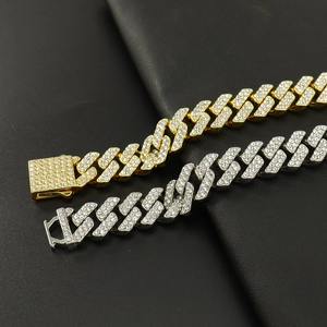 Detailed close-up of gold and silver diamond-encrusted Cuban link chains on black leather