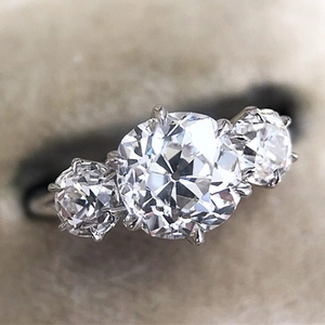 Elegante tweekleurige ring met drie ronde zirkonia stenen in een klassieke zetkast