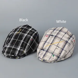 Vintage distressed plaid newsboy caps in black and white with artful paint splatter