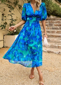 Détail de la robe midi fleurie bleue avec col en V, manches bouffantes et taille cintrée