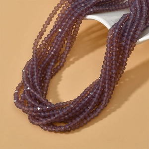 Detail of 4mm faceted purple glass spacer beads on a white stand for DIY jewelry making