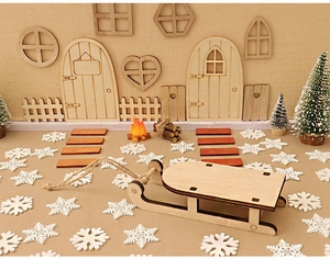 Miniature wooden Christmas scene set with sled fence and door on khaki background