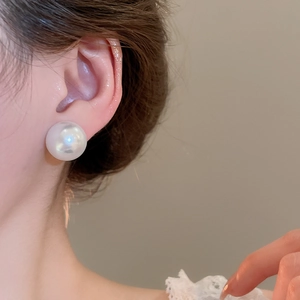 Close-up of a model wearing a large 16-20mm white pearl stud earring with elegant luster