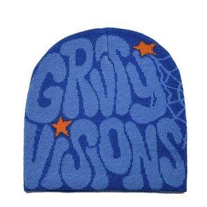 Blue knit beanie with GRVTY VISONS lettering and orange star patterns on white background