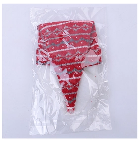 Detail of red and grey knitted Santa Claus wine bottle hat in clear plastic packaging