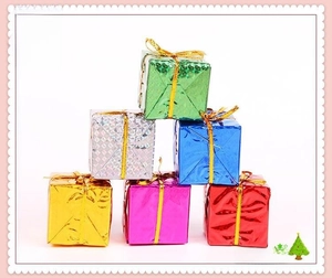 Macro shot of colorful metallic Christmas gift boxes with gold ties for tree decoration