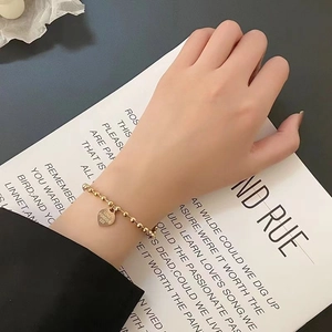 Elegant gold beaded titanium steel heart bracelet engraved with Love Forever 520 worn on wrist