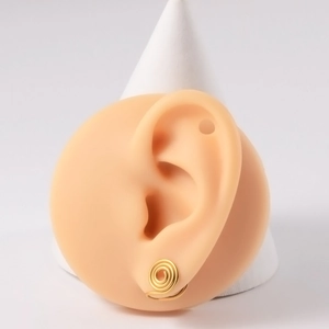 Detailed view of a gold spiral non-pierced ear cuff on a realistic ear model