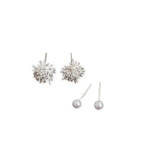 Set of silver firework flower studs and elegant pearl earrings on white background