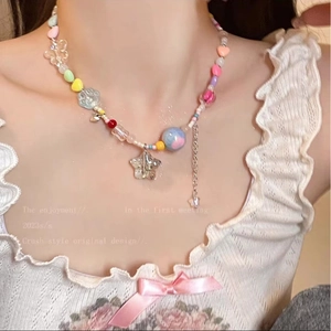Détail du collier de perles coloré Y2K avec pendentifs papillon et étoile sur modèle