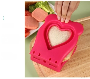 Macro detail of heart sandwich sealer tool cutting toast on a wooden board