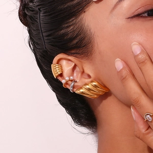 Detail of 18K gold shell earrings and pearl ear cuffs on a model for a modern look