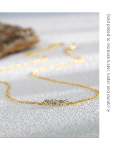 Macro detail of gold plated necklace with marquise-cut sparkling zircon stone pendant
