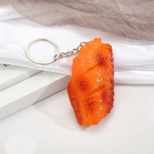 Realistic roasted chicken wing keychain with silver metal ring on white background