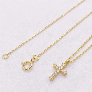 Detail of gold cross pendant with cubic zirconia stones and adjustable spring ring clasp