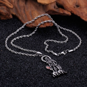 Close-up of gothic stainless steel pendant with shepherd relief and red gemstone