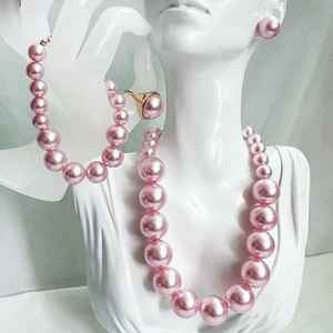 Detail of pink pearl jewelry set including necklace, bracelet, earrings and ring on mannequin