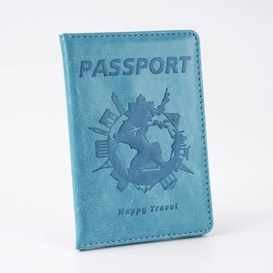 Detail of bright blue faux leather passport cover with world landmark embossing